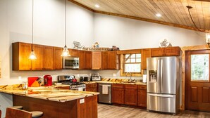 A modern kitchen with wooden cabinets, stainless steel appliances, and a central island.