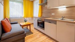 Uma cozinha compacta com forno embutido, pia e um pequeno espaço de refeições.