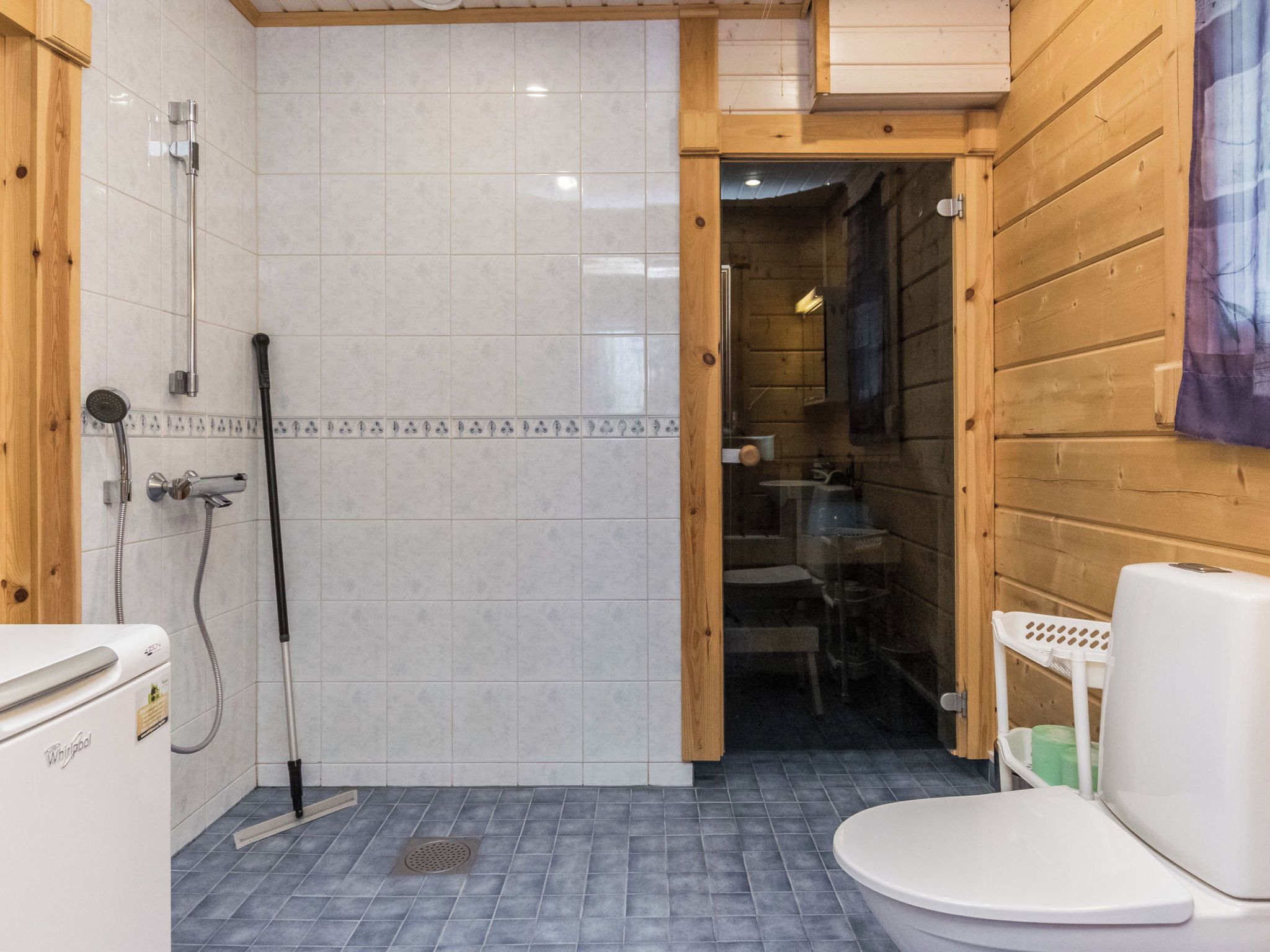A bathroom with a shower, toilet, and a sink.