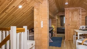 A wooden interior with a staircase, a dining area, and a bedroom. - Villa eerola by Interhome (Juva)