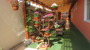 A covered outdoor area with a wooden pergola, potted plants, and a seating area with chairs and a table. - Tababela Land (Tababela)