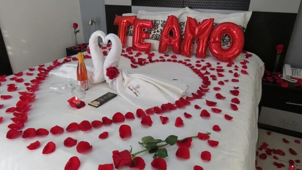 A bed with rose petals, a bottle, and a swan-shaped balloon. - Tababela Land (Tababela)