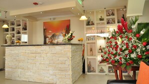 A reception area with a stone counter, shelves with various items, and a large painting on the wall. - Tababela Land (Tababela)