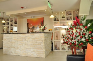 A reception area with a stone counter, shelves with various items, and a large painting on the wall. - Tababela Land (Tababela)