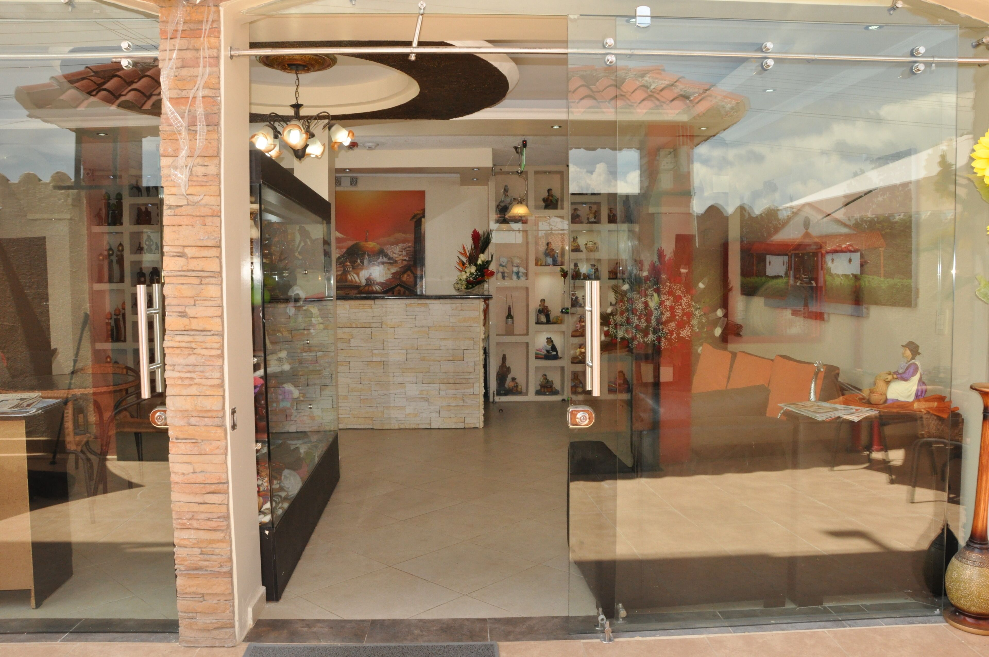 Un vestíbulo de hotel con mostrador de recepción, zona de estar y detalles decorativos.