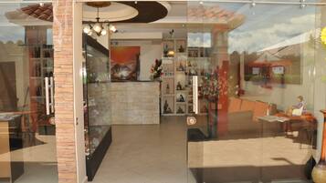 Un vestíbulo de hotel con mostrador de recepción, zona de estar y detalles decorativos.