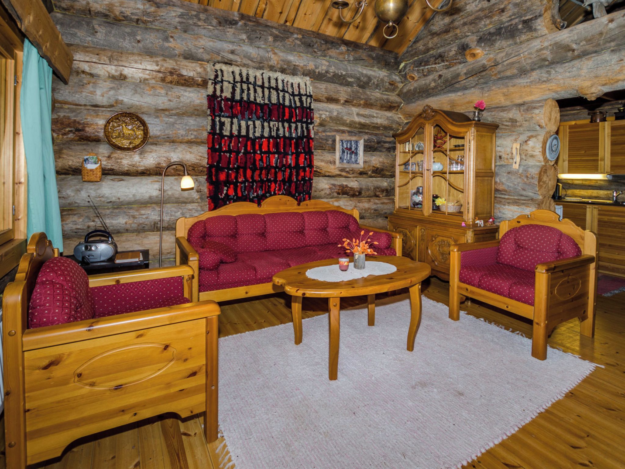 L'intérieur d'une cabane en rondins, avec un ensemble de canapés, un buffet en bois et une table à manger.