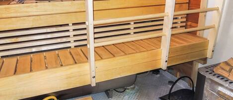 A kitchen with wooden shelves, a metal pot, and a tiled floor.