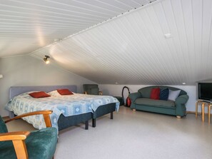 A bedroom with a bed, a sofa, a chair, and a television. - Prokatti by Interhome (Sotkamo)