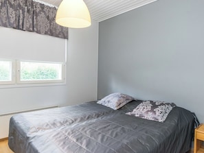 A bedroom with a bed, a window, a radiator, and a ceiling light. - Prokatti by Interhome (Sotkamo)