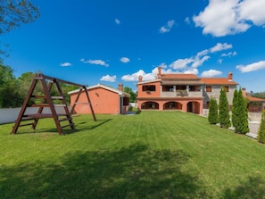 Une grande maison avec une pelouse bien entretenue et un portique.