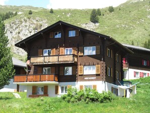 Ein mehrstöckiges Holzhaus mit Balkonen und einem Schild, auf dem "ABENDROT" steht.