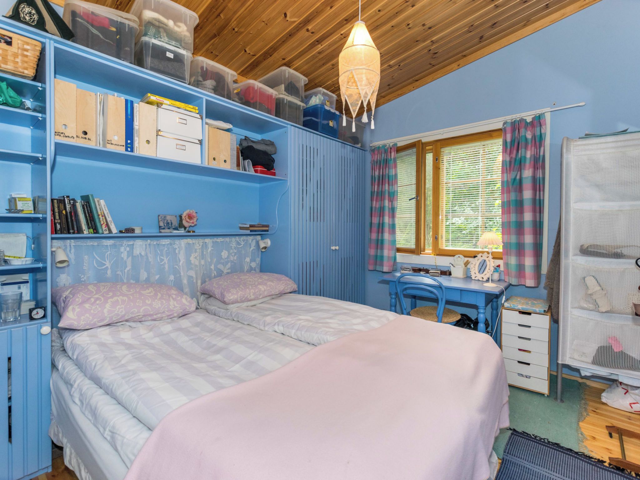 Une chambre à coucher comprenant un lit, un bureau et des meubles de rangement.