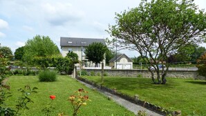 A residential area with a house, a stone wall, and a grassy lawn. - Charming cottage in Saint-Bonnet-de-Rochefort with private garden (Saint-Bonnet-de-Rochefort)