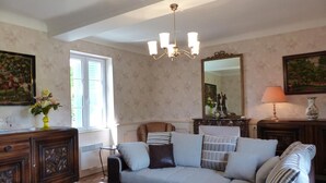 A living room with a sofa, coffee table, and a chandelier. - Charming cottage in Saint-Bonnet-de-Rochefort with private garden (Saint-Bonnet-de-Rochefort)