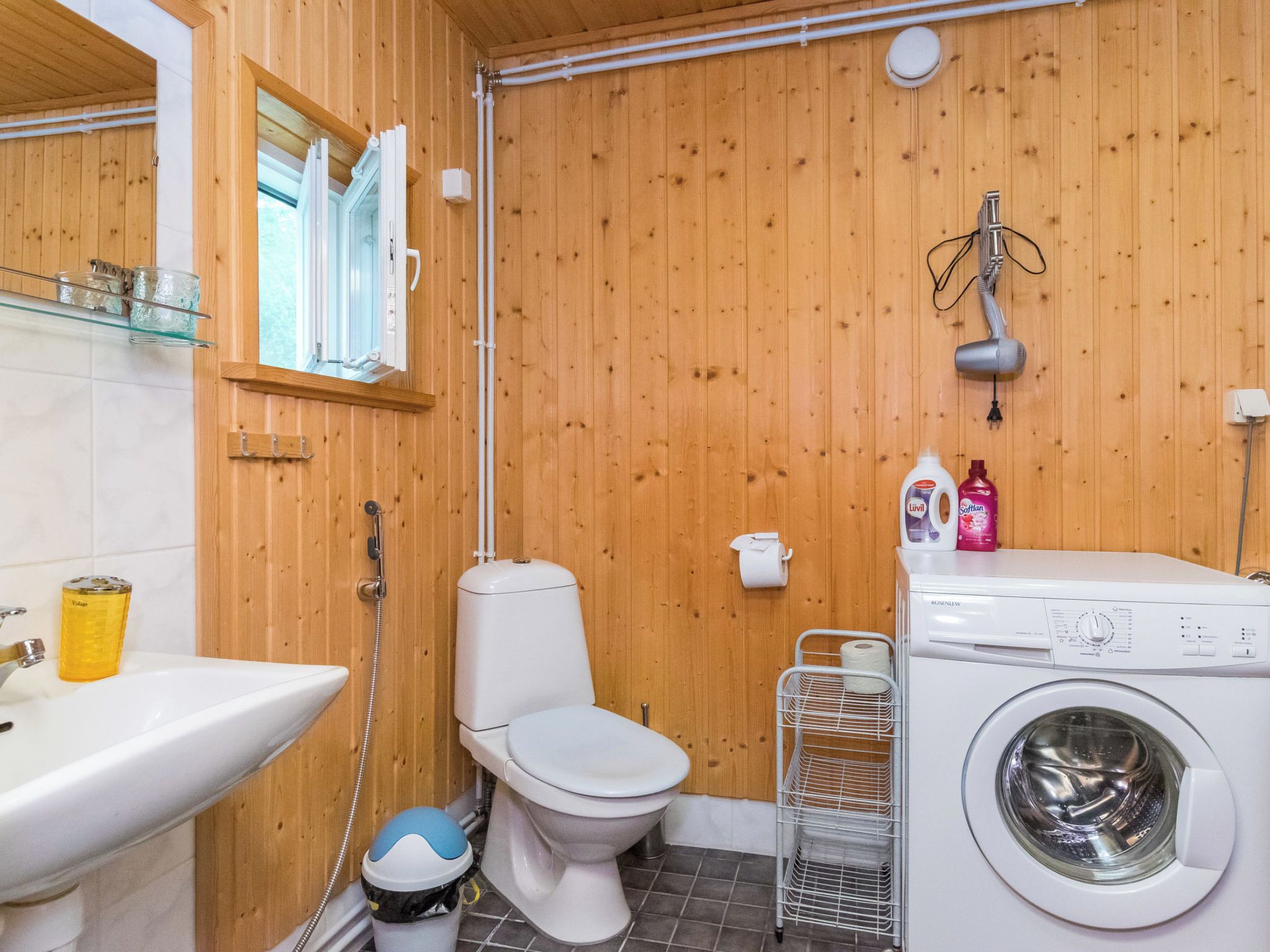 Pieni kylpyhuone, jossa on wc, pesuallas ja pesukone.
