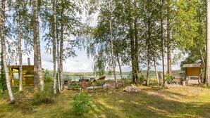 A rustic cabin with a wooden deck, surrounded by birch trees, overlooking a calm lake. - Vacation home Pöllö by Interhome (Kouvola)