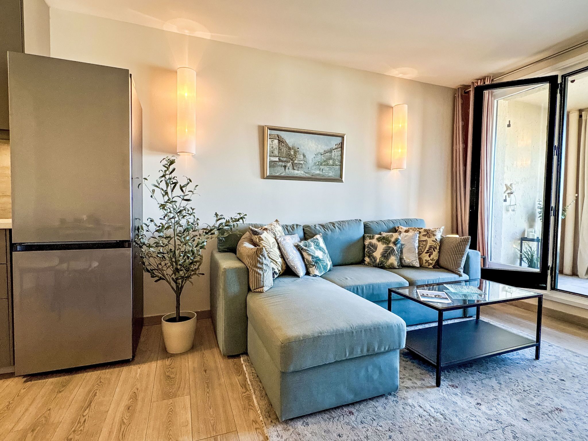 A modern living room with a sofa, coffee table, and a potted plant.