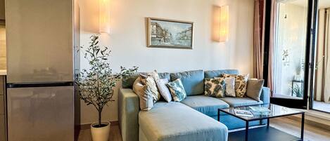 A modern living room with a sofa, coffee table, and a potted plant.