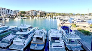 Un port esportiu amb diversos iots amarrats, un edifici del port i un fons d'edificis residencials.
