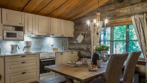 A rustic kitchen with wooden beams, a stone wall, and a window overlooking greenery. - Mäkitorppa by Interhome (Asikkala)