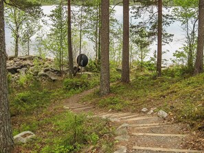 A forested area with a wooden trail leading to a body of water. - Ulpukka by Interhome (Juuka)