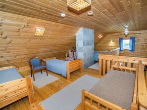A wooden cabin with a loft bedroom, a small seating area, and a staircase. - Kissankello by Interhome (Juuka)