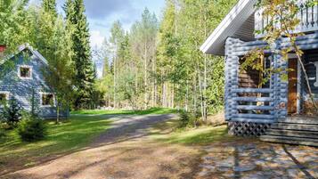 A log cabin with a stone pathway leading to the entrance.