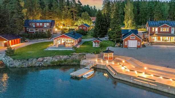 A lakeside residential area with houses, a dock, and a small boat. - Villa blomvik by Interhome (Porvoo)