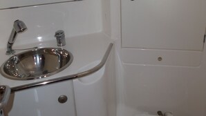 A small, white bathroom with a sink, a toilet, and a mirror. - Stays and unusual nights at the port of Morlaix on a 12-meter sailboat (Morlaix)