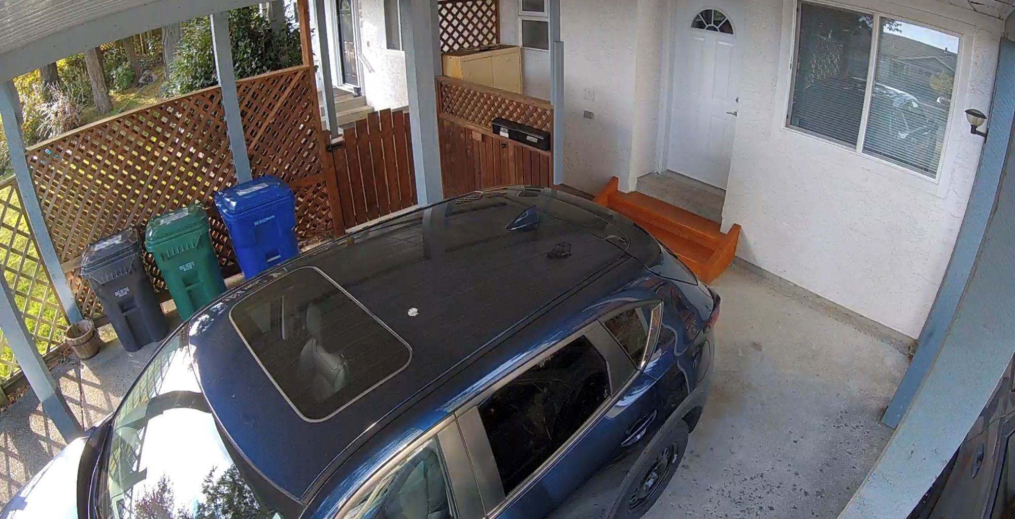 A covered carport with a blue car parked inside.
