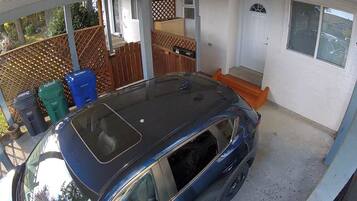A covered carport with a blue car parked inside.