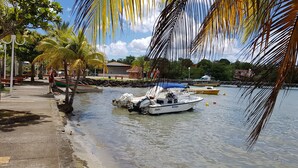 A waterfront area with boats docked, palm trees, and a building labeled "Ville des Trois-Îles". - ■ BEAUTIFUL T2 CLIMATISE IN VILLA SEA VIEW - RAVINALA MARTINIQUE ■ (LES TROIS ILETS)