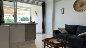 A compact living space with a kitchenette, a sofa, and a coffee table. - ■ BEAUTIFUL T2 CLIMATISE IN VILLA SEA VIEW - RAVINALA MARTINIQUE ■ (LES TROIS ILETS)