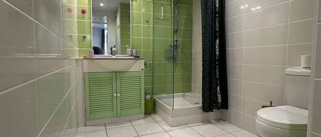 A bathroom with a shower, toilet, and sink.