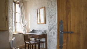 Ein Zimmer mit Holztür, einem Vorhangfenster, einer Marmorplatte, einem Holzstuhl und einem Schrank.