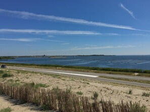 Una strada costiera con una spiaggia sabbiosa e un cielo azzurro limpido.