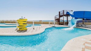 Un espace piscine équipé d’un toboggan et de bouées gonflables.