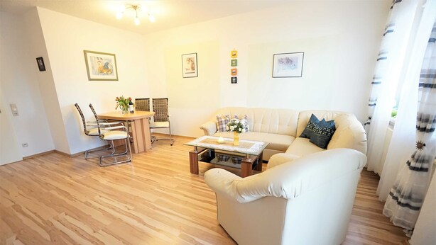 Un salon comprenant un canapé, une table basse et un coin repas avec des chaises et une table.