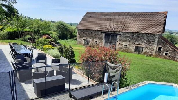 A pool area with a stone building in the background. - Renovated farmhouse with private pool and pets allowed (Échassières)