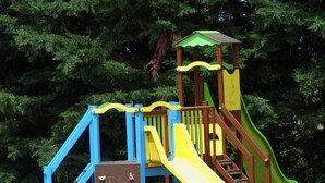 A playground with a slide, climbing wall, and a small tower structure. - Cottage with AC - 4 guests (Meillard)