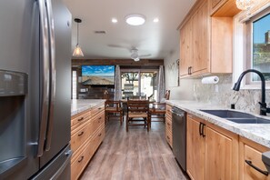 Enjoy cooking in this well-equipped kitchen with a central island, stainless steel appliances, and a large window for natural light.
