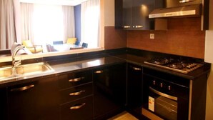 Een moderne keuken met een roestvrijstalen spoelbak, zwarte kastjes en een ingebouwde oven.