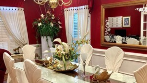 En matplats med ett glasbord, vita stolar och blomsterarrangemang som mittpunkter.
