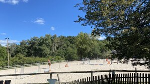 Espacio al aire libre cercado con suelo arenoso, posiblemente para actividades ecuestres.
