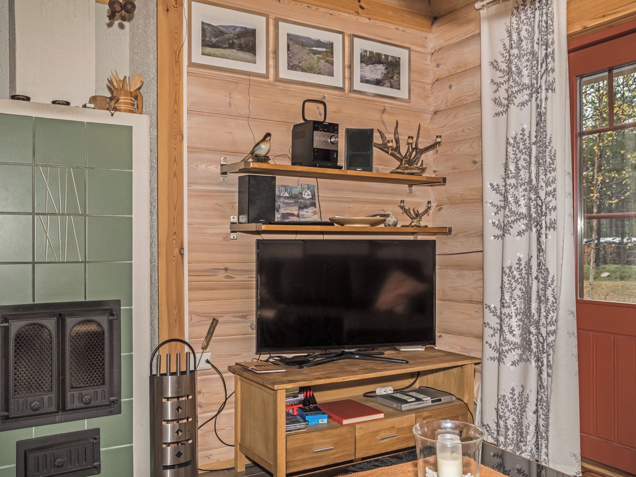Un salon chaleureux avec une télévision, des étagères en bois et une cheminée.