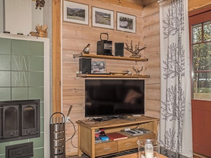 Un salon chaleureux avec une télévision, des étagères en bois et une cheminée.