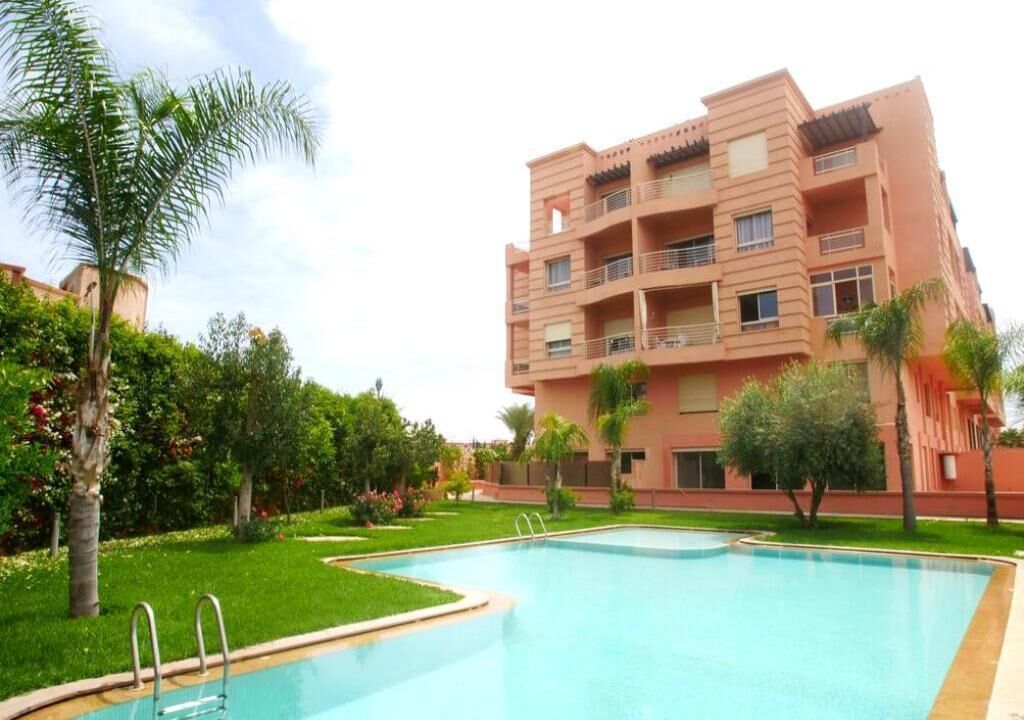 A multi-story building with a swimming pool in the foreground.