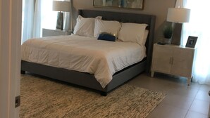 A bedroom with a bed, a ceiling fan, a nightstand with a lamp, and a painting on the wall. - Paradise on the lake (Centre)