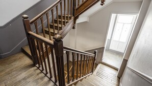 Una escalera de madera con barandilla que lleva a un piso superior.